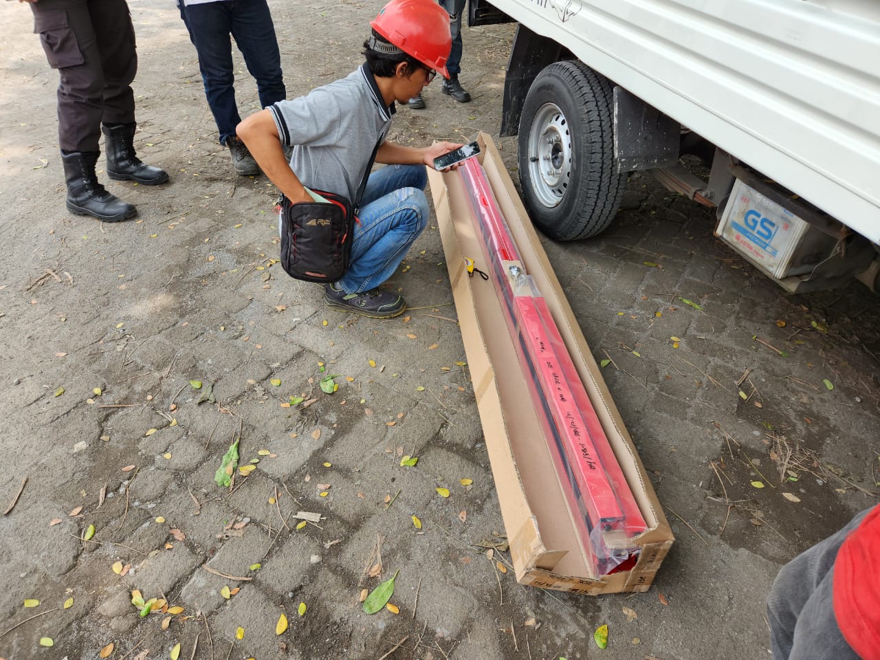 Teknisi menurunkan brankas dari kendaraan pengangkut
