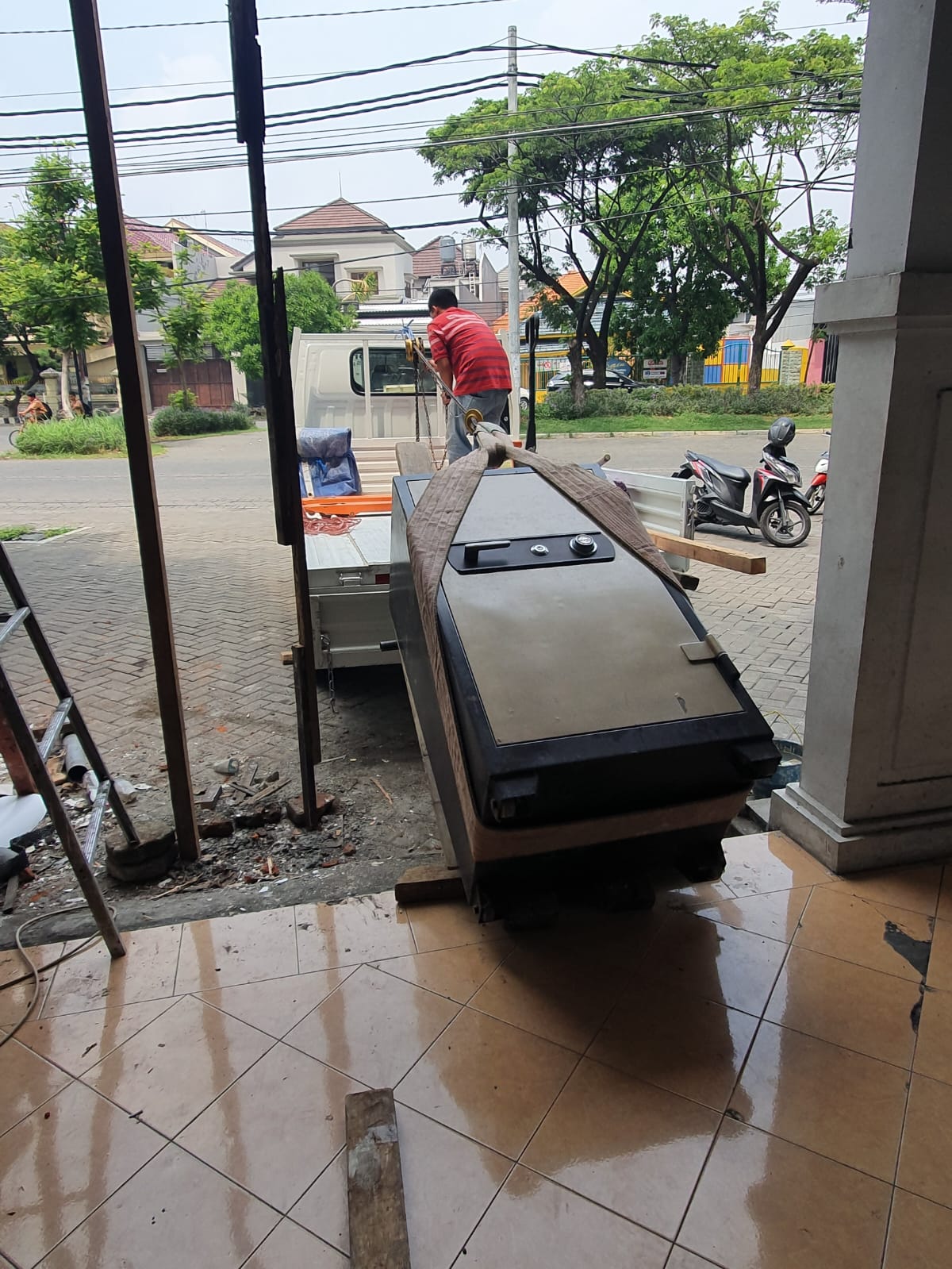 Brankas diturunkan dari kendaraan lewat papan luncur menuju pintu masuk