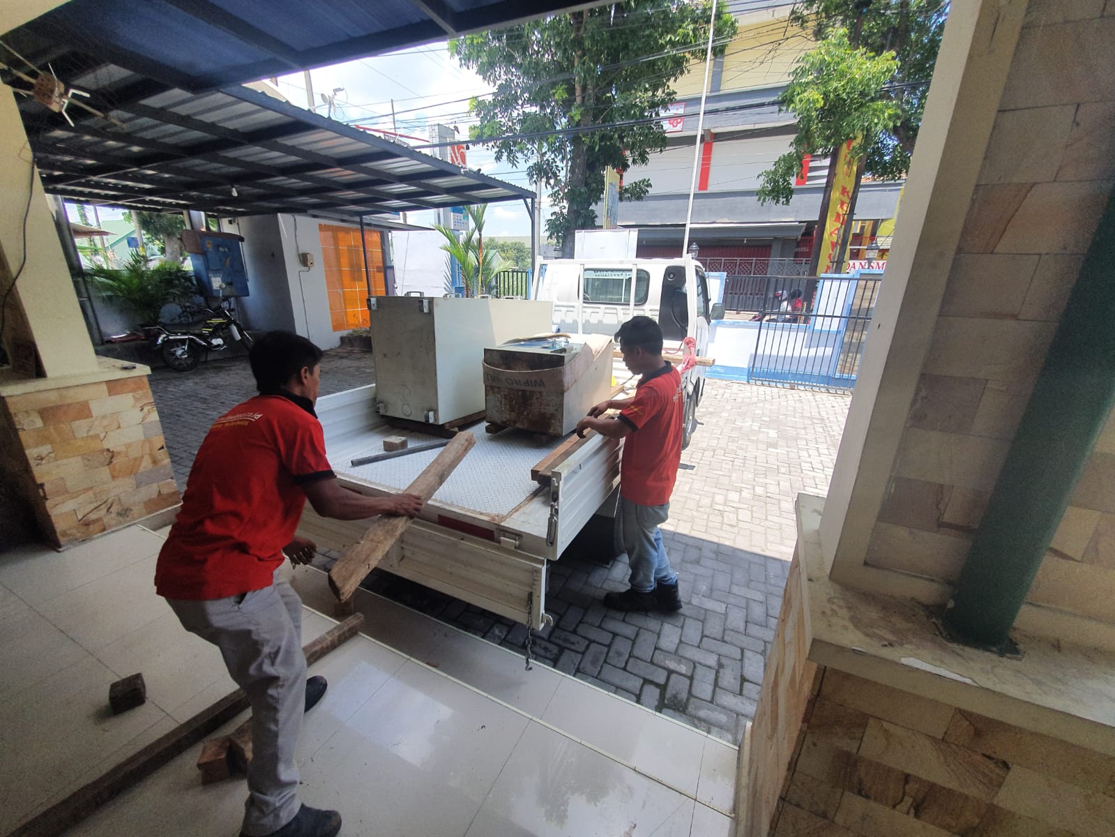 Teknisi bersiap menurunkan brankas dari kendaraan