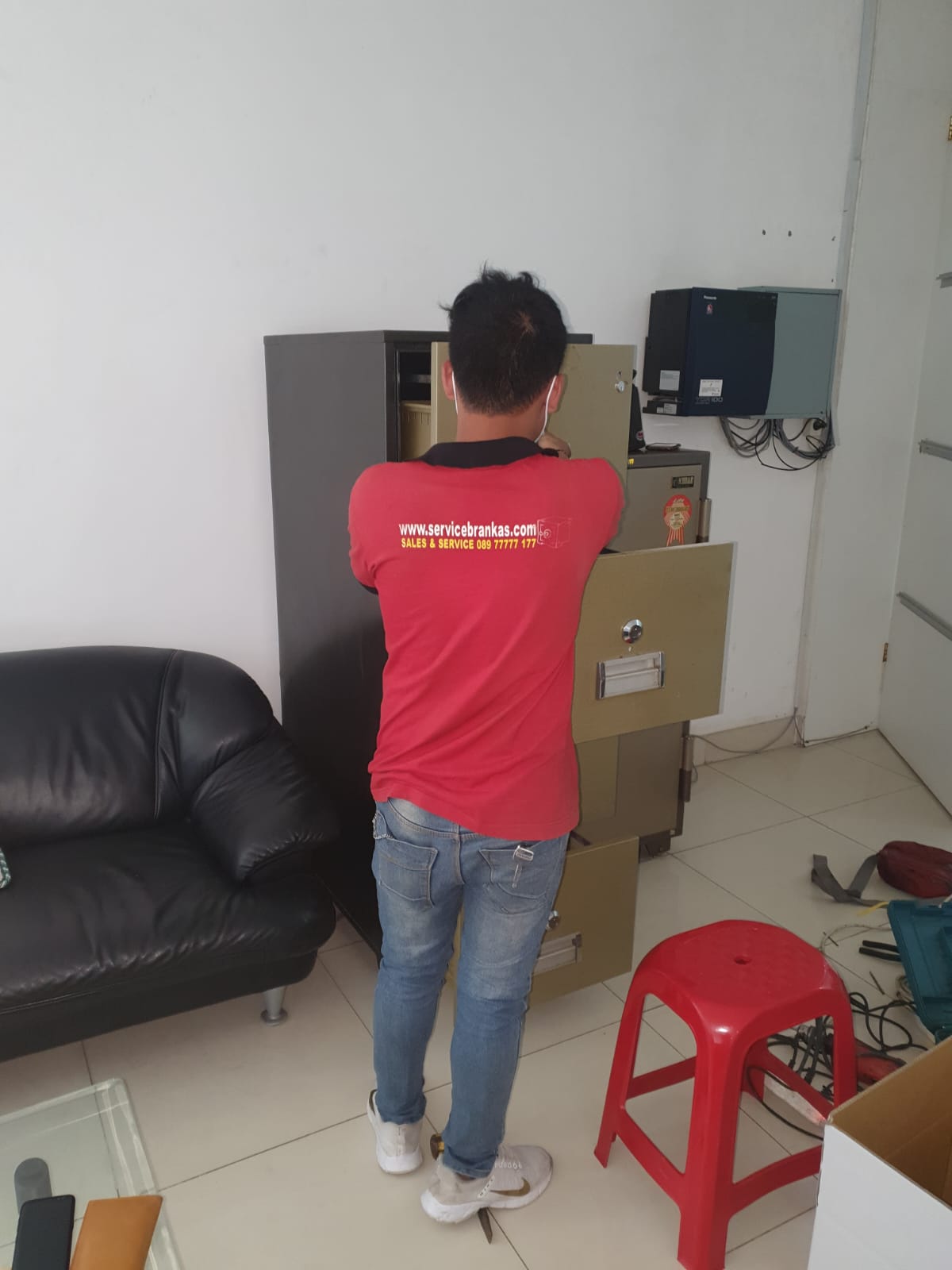 Teknisi sedang memperbaiki mekanis brankas