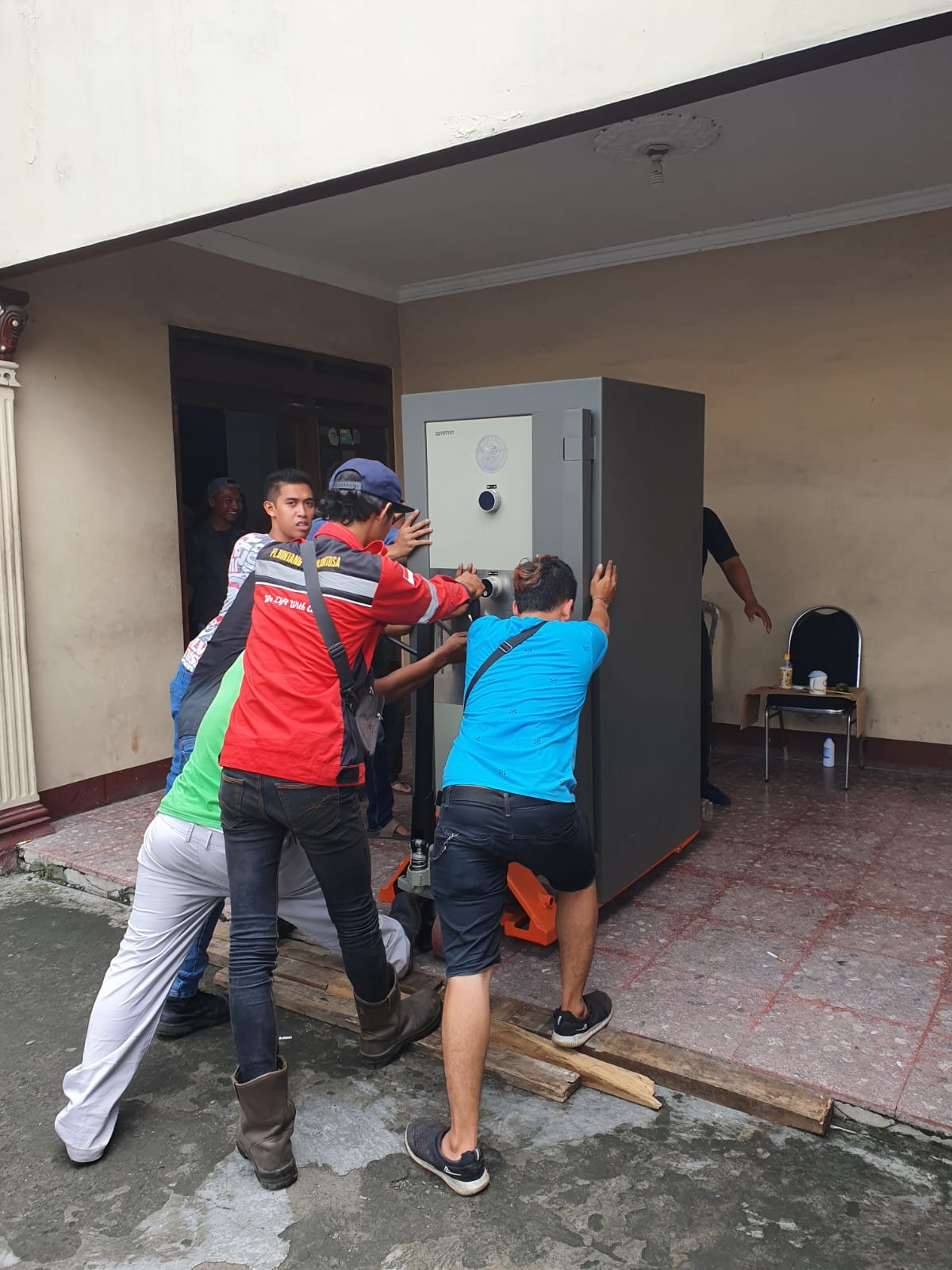 Tim mendorong brankas ke posisi pemasangan