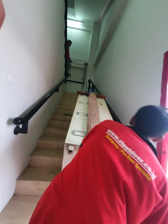 Teknisi memindahkan unit mobile file melewati tangga gedung